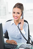 Smiling brunette businesswoman phoning