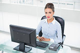 Focused brunette businesswoman sitting at her desk