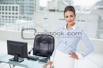 Smiling businesswoman standing hand on hips