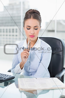 Focused brunette businesswoman looking at documents