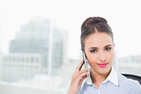 Smiling brunette businesswoman phoning with smartphone