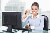 Happy brunette businesswoman holding disposable cup