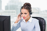 Calm brunette businesswoman using headset