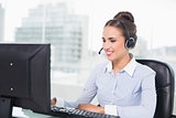 Happy brunette businesswoman using headset