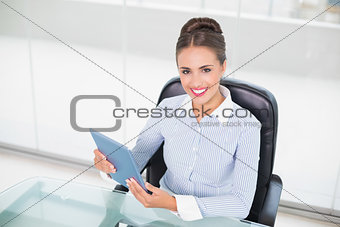 Smiling brunette businesswoman using tablet