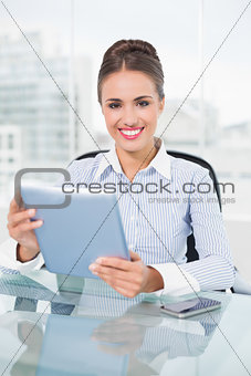 Happy brunette businesswoman holding tablet