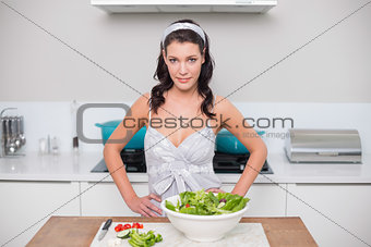 Happy pretty brunette making salad