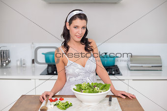 Peaceful pretty brunette preparing healthy salad