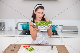 Content pretty brunette holding healthy salad