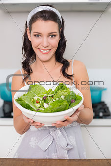 Cheerful pretty brunette showing healthy salad