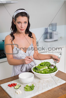 Peaceful pretty brunette mixing healthy salad