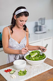 Focused pretty brunette mixing healthy salad