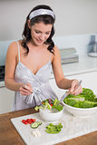 Cheerful cute brunette preparing healthy salad