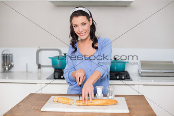 Cheerful gorgeous model cutting baguette