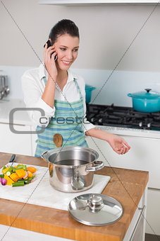Cheerful pretty woman wearing apron having a call