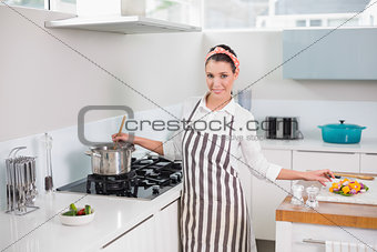 Cheerful pretty woman with apron cooking
