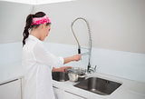 Focused charming woman cleaning dishes
