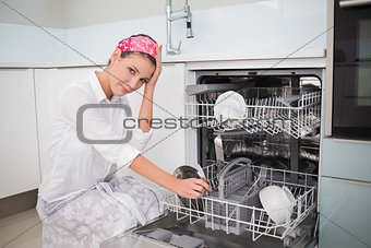 Worried charming woman using dish washer