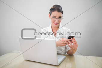 Cheerful businesswoman with classy glasses texting