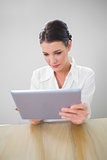 Focused businesswoman working on tablet pc