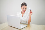 Happy pretty businesswoman shopping online using laptop