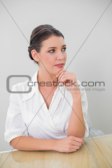 Pensive brown haired businesswoman posing