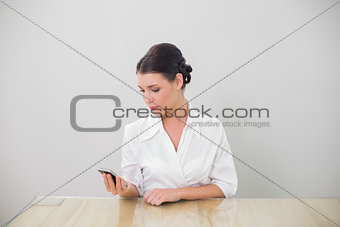 Calm brown haired businesswoman text messaging