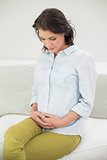 Calm pregnant brown haired woman holding her belly