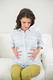 Pretty pregnant brown haired woman holding her belly