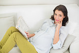 Beautiful pregnant brown haired woman reading a newspaper