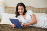 Serious pretty brown haired woman using a tablet pc