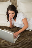 Peaceful pretty brown haired woman using a laptop