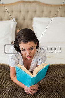 Peaceful pretty brown haired woman reading a book