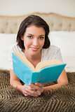 Smiling pretty brown haired woman reading a book