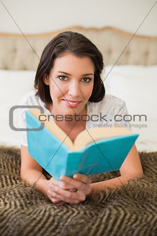 Smiling pretty brown haired woman reading a book