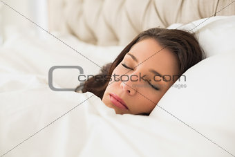 Dreamy pretty brown haired woman sleeping in her bed