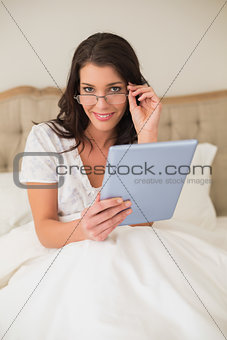 Happy pretty brown haired woman using a tablet pc