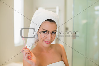 Seductive natural brown haired woman holding a toothbrush
