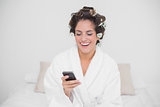 Laughing natural brunette looking at smartphone