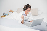 Content natural brunette using credit card and laptop