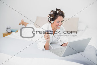 Content natural brunette using credit card and laptop