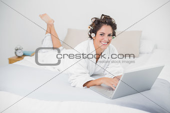 Smiling natural brunette using laptop
