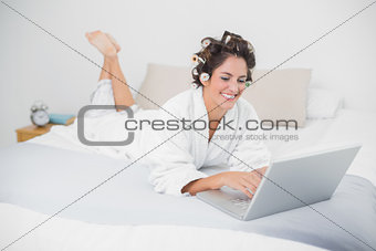 Cheerful natural brunette using laptop