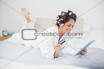 Content natural brunette using tablet and credit card
