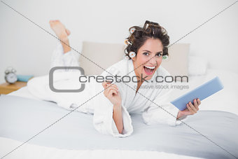 Laughing natural brunette using tablet and credit card