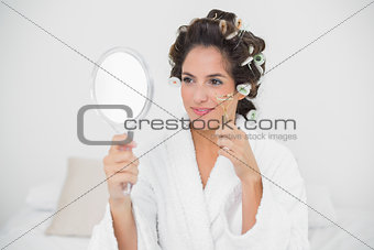 Smiling natural brunette using eyelash curler