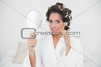 Frowning natural brunette holding eyelash curler