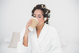 Peaceful natural brunette drinking from disposable cup
