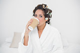 Calm natural brunette drinking from disposable cup