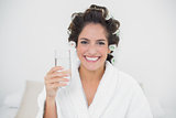 Smiling natural brunette holding glass of water
